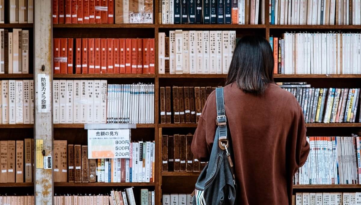 Mujer de espaldas leyendo los mejores libros sobre liderazgo